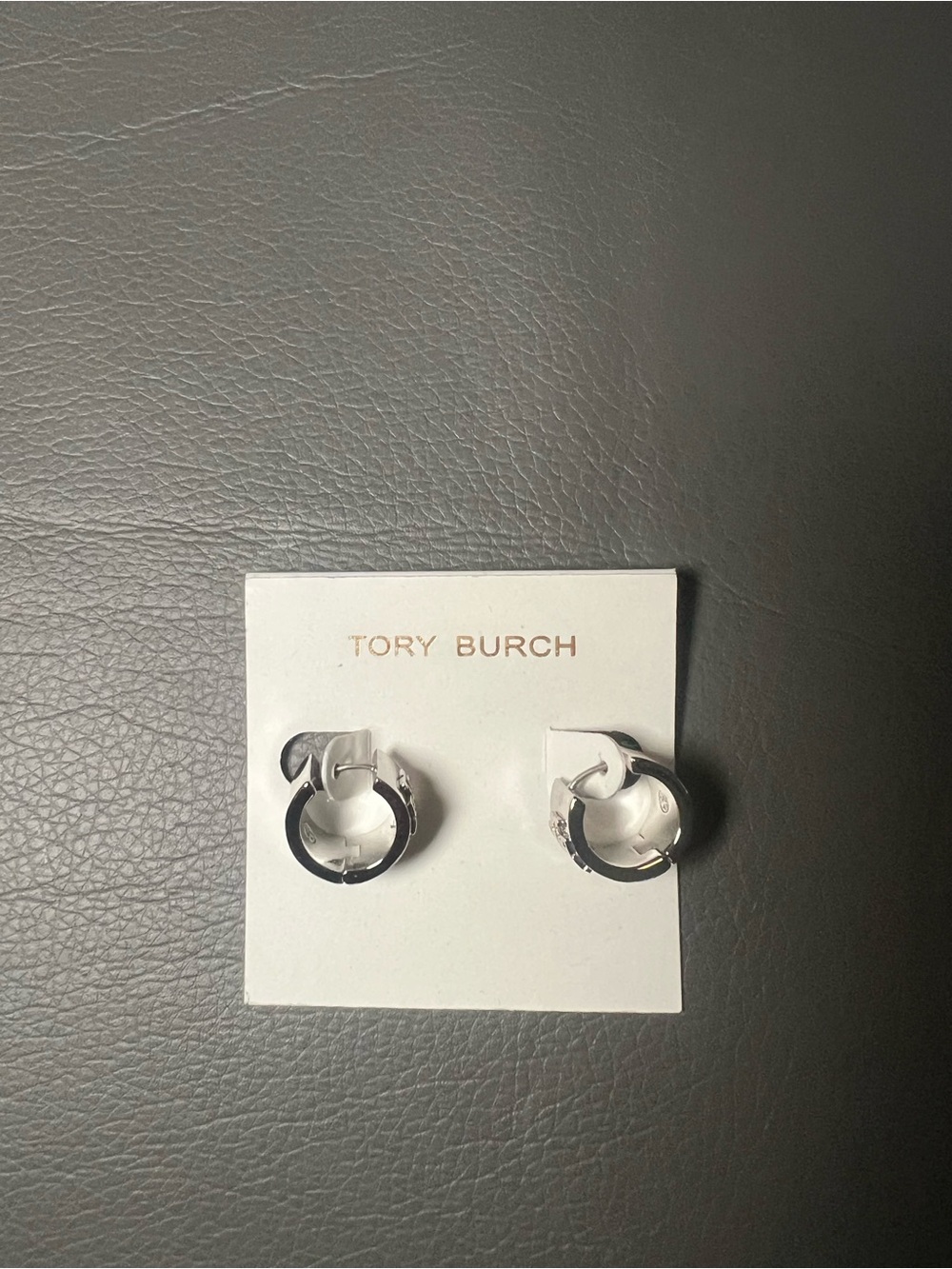 Tory Burch “Britten Huggie” silver small hoop earrings